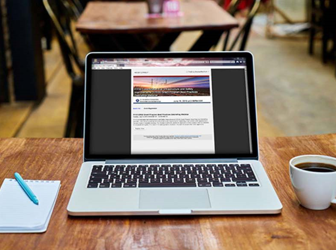 Laptop on table with image of webinar page